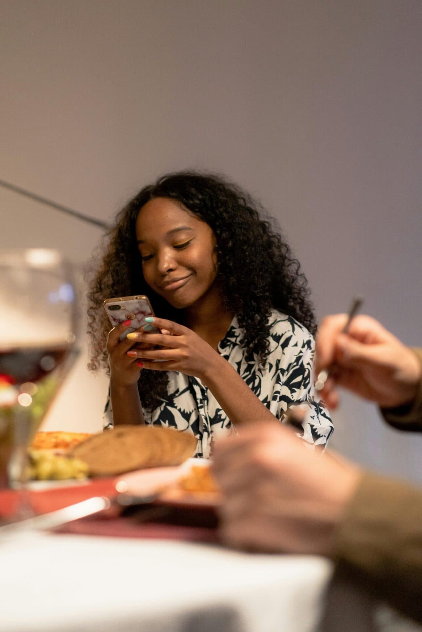 girl-sitting-in-printed-blouse-holding-smartphone